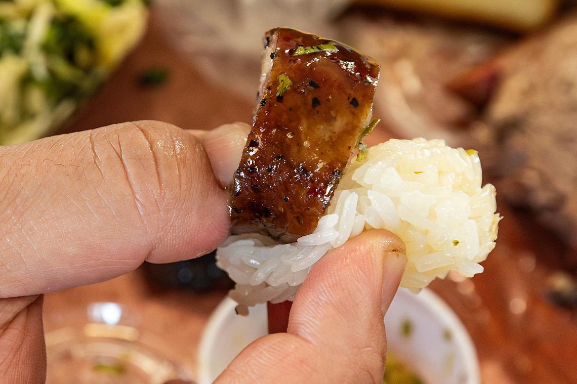 The proper way to eat the smoked Lao sausage is to hold a piece with sticky rice and dip them together into the jeow som, a a popular Laotian sweet and sour dipping sauce made with fresh garlic, chiles, lime juice, sugar, and fish sauce.
