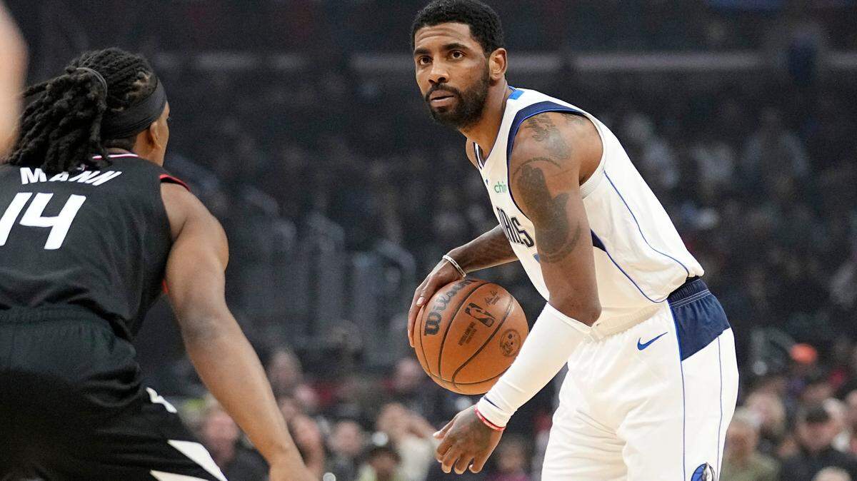 Dallas guard Kyrie Irving, right, dribbles as Los Angeles Clippers guard Terance Mann defends during his Mavericks debut on Wednesday in Los Angeles.