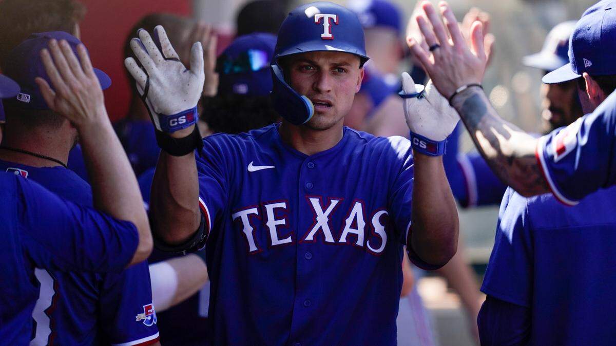 Texas Rangers’ Corey Seager, right, celebrates in the dugout after hitting a home run in 2022. He is entering his second season in Arlington.
