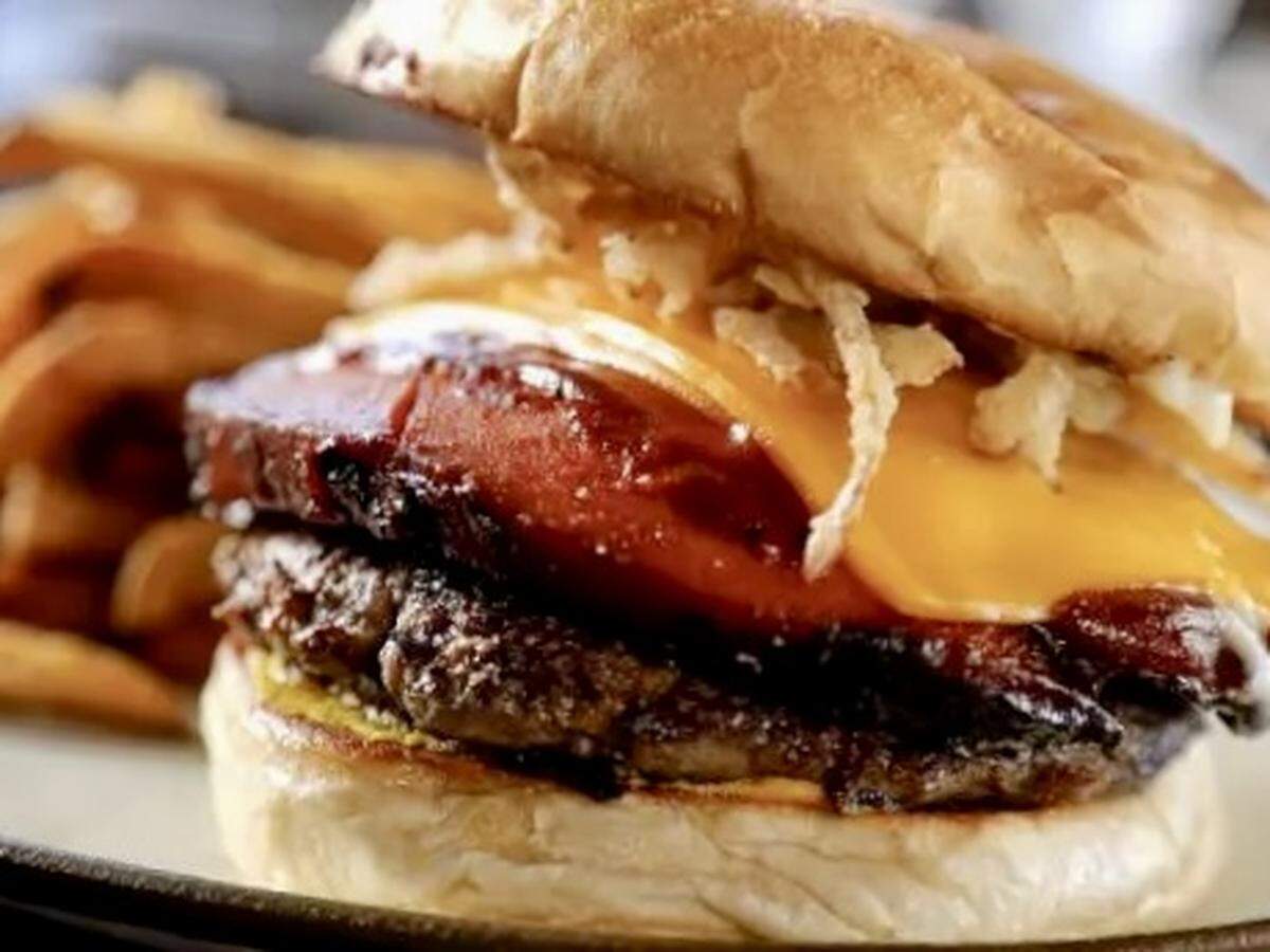 The “Bolo Burger” at Fred’s Texas Cafe features both beef and smoked bologna with onion strings.