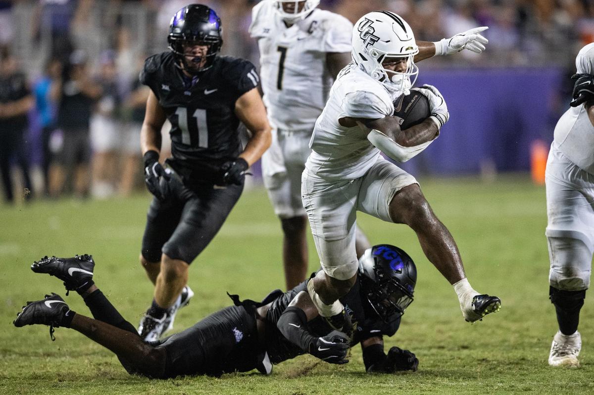 UCF running back RJ Harvey (7) avoids a tackle from TCU safety Jamel Johnson (2) to score a touchdown in the third quarter of a BIG XII conference game between TCU and UCF at Amon G. Carter Stadium in Fort Worth on Saturday, Sept. 14, 2024.
