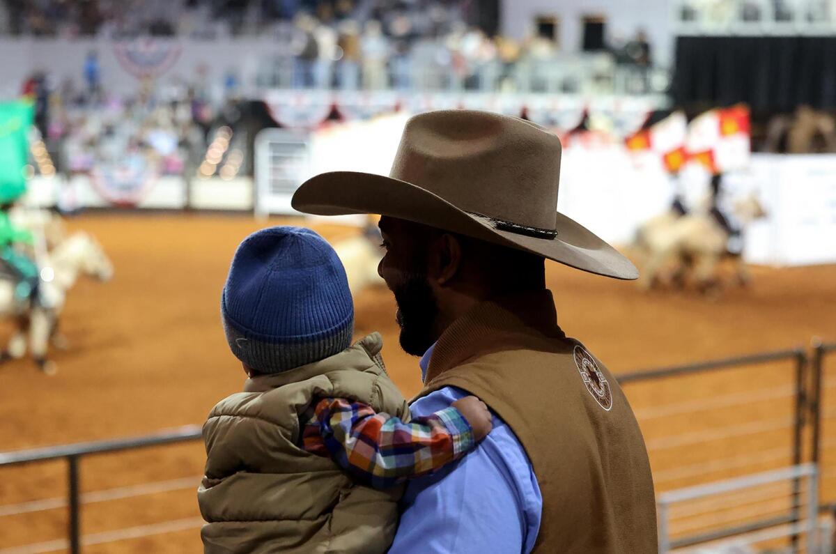 Fort Worth City Councilman Jared Williams watches the Cowboys of Color Rodeo with his seven-month-old son Jameson on Monday, Jan. 20, 2025.
