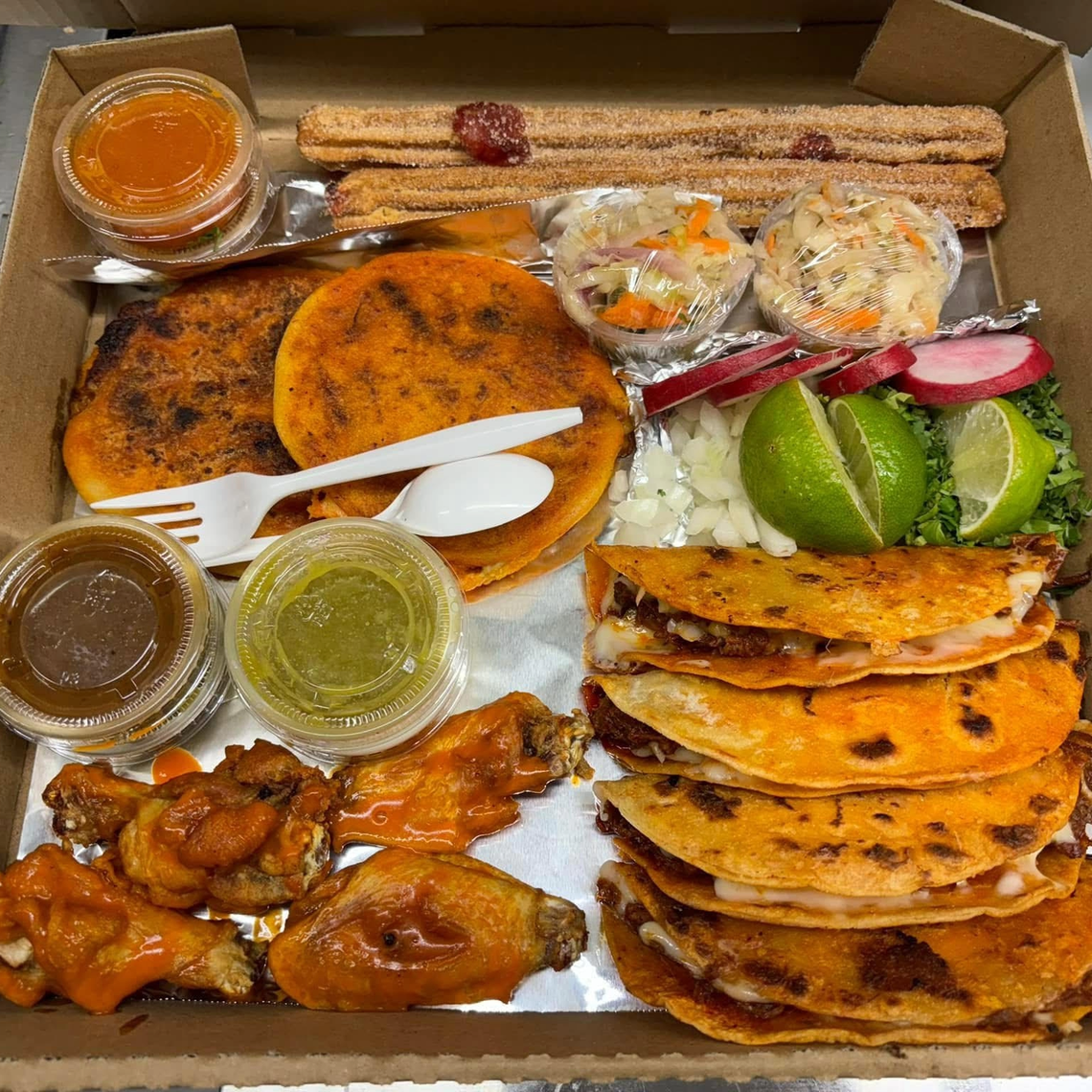 Birria happy meal. The happy meal comes with 4 QuesoBirria tacos, 2 Birria pupusas, 1 broth, 2 churros and 4 wings seen alongside sauces, limes, cilantro and onions at La Unión Restaurant 2 in Fort Worth on July 29, 2025.