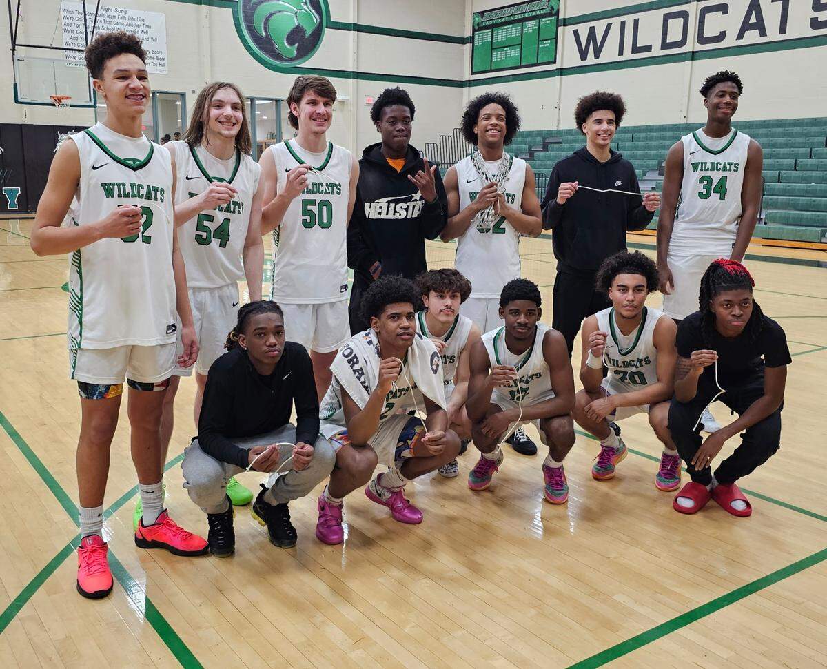 The Kennedale varsity boys basketball team poses after cutting down the net to celebrate an undefeated District 12-4A championship after a game against Venus on Friday, February 7, 2025 at Kennedale High School in Kennedale, Texas