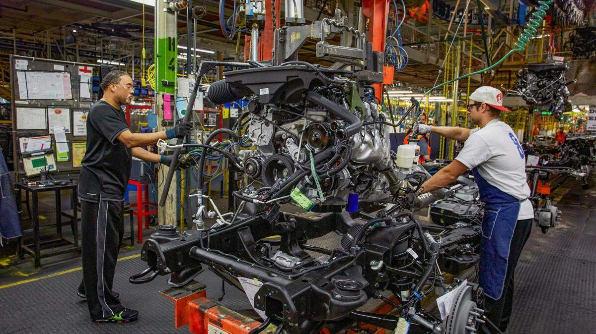Workers install a propulsion system in a 2021 Chevrolet Tahoe at GM’s Arlington Assembly plant.
