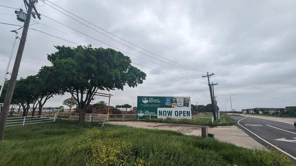 The outside of a landscape mulch facility next to a country road with an apartment complex off in the background