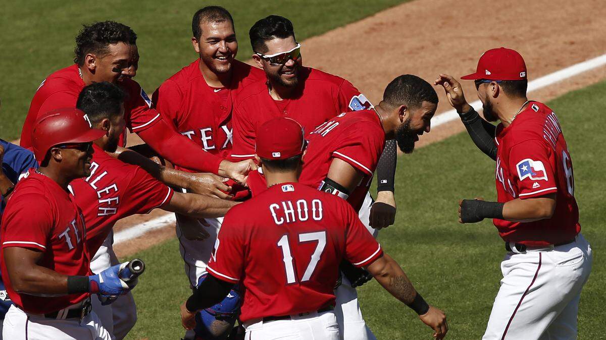 Nomar Mazara, second from right, is mobbed by his Rangers teammates after connecting for the game-winning homer in the 10th inning.