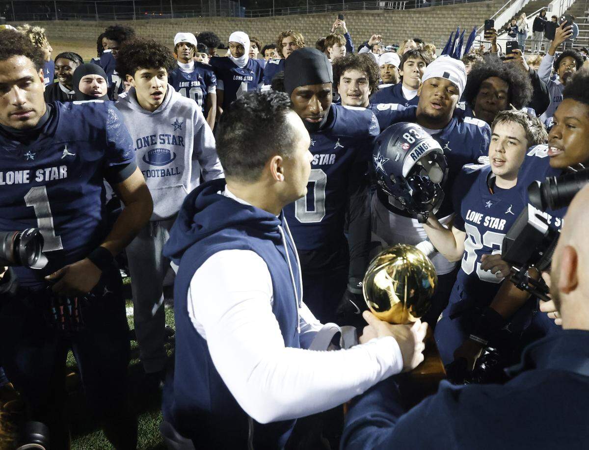 Frisco Lone Star head coach Jeff Rayburn prepares to present the trophy to his team after defeating Aledo in a UIL Class 5A Division I Semifinal on Friday Dec. 12, 2025 at Vernon Newsom Stadium in Mansfield, Texas.
