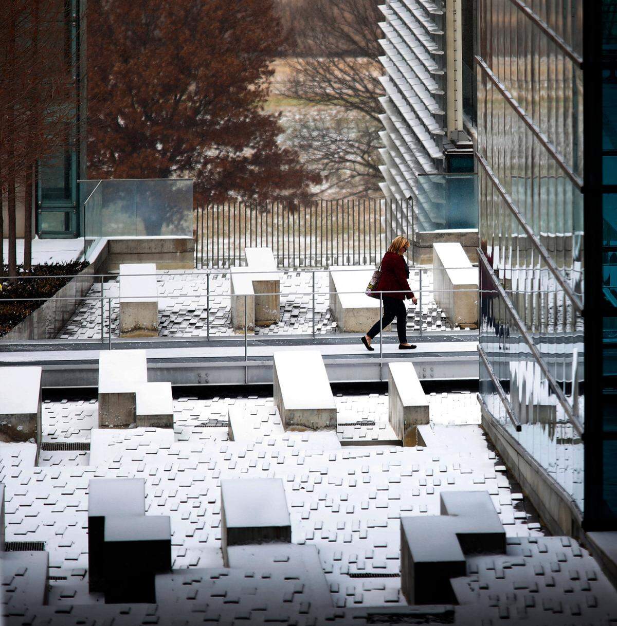Feb. 6, 2014: A pedestrian walks between buildings at the Tarrant County College’s east campus as snow falls in Fort Worth.