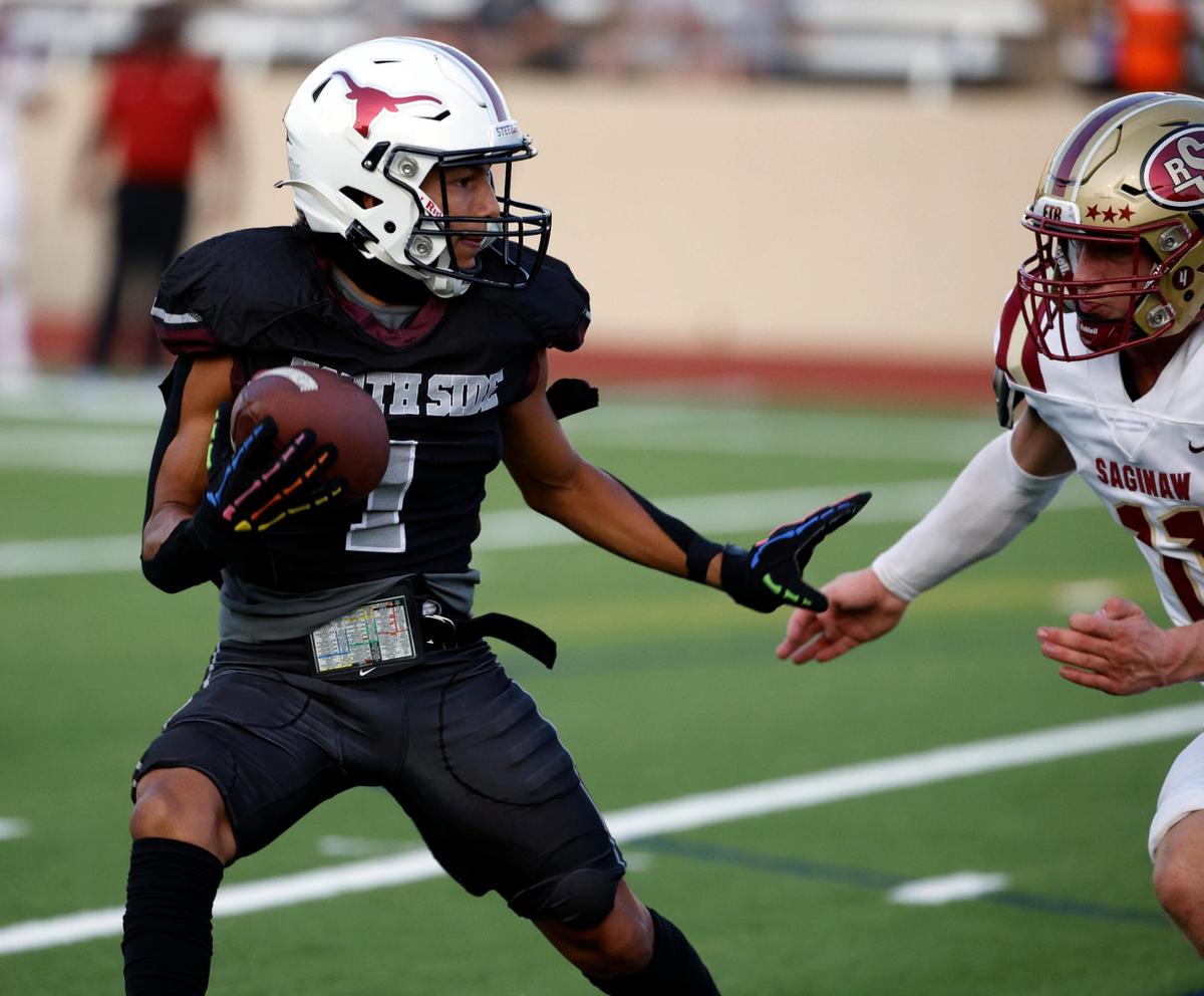 North Side wide receiver Lorenzo Perez (1) prepares to stiff arm Saginaw linebacker Tyler Self (11) in the first half of a UIL football game at Farrington Field in Fort Worth,Texas, Friday Sept. 01, 2023. North Side led 14-7 at the half. (Special to the Star-Telegram Bob Booth)