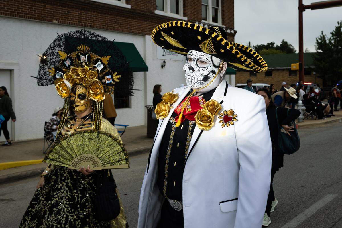 Parade participants walks down Main Street for the Dia De Los Muertos Parade in Northside Fort Worth on Saturday, Nov. 1, 2025.
