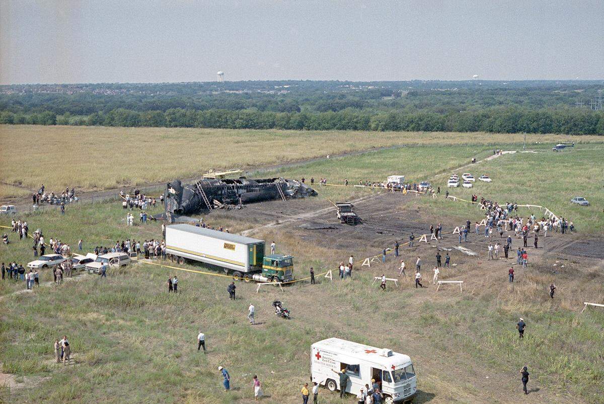 Aug. 31, 1988: An aerial view of the Delta Flight 1141 plane crash at Dallas-Fort Worth International Airport. A Red Cross van is seen parked near the scene of the wreckage. The deceased were placed in the makeshift refrigerated morgue transport truck, set up on site by the Tarrant County Medical Examiner’s Office. The Boeing 727 struck an antenna array about 1,000 feet beyond the end of runway 18L and came to rest about 3,200 feet beyond the end of the pavement.
