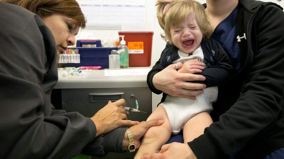 LVN Tanya Roland vaccinates Fatima Wolfe, the 1-year-old daughter of Jordan Wolfe, at the Shots for Tots vaccination clinic at St. John’s Community Center on Thursday February 5, 2015. Fatima got six shots that included a variety of vaccinations including the measles.