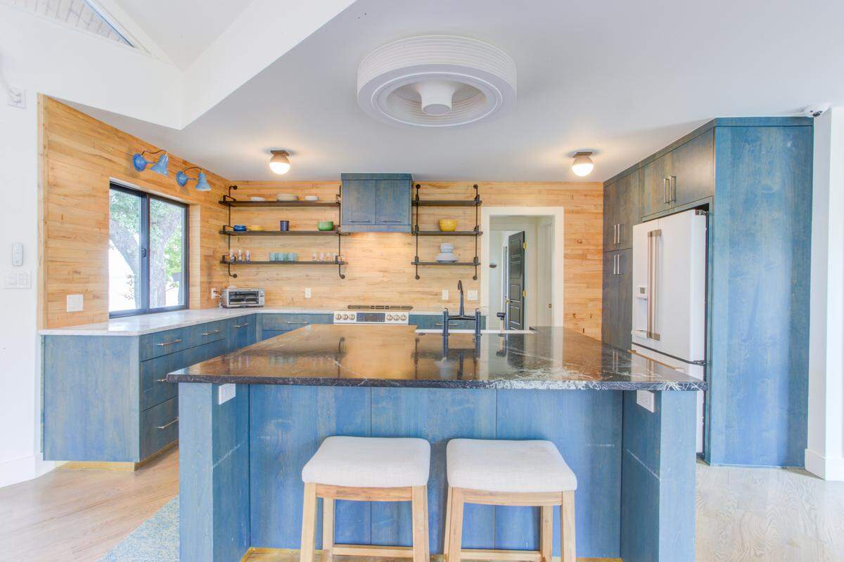 The kitchen backsplash in this beach house is actually from old basketball flooring. The blue cabinets were meant to match the “crystal blue water” of Eagle Mountain Lake.