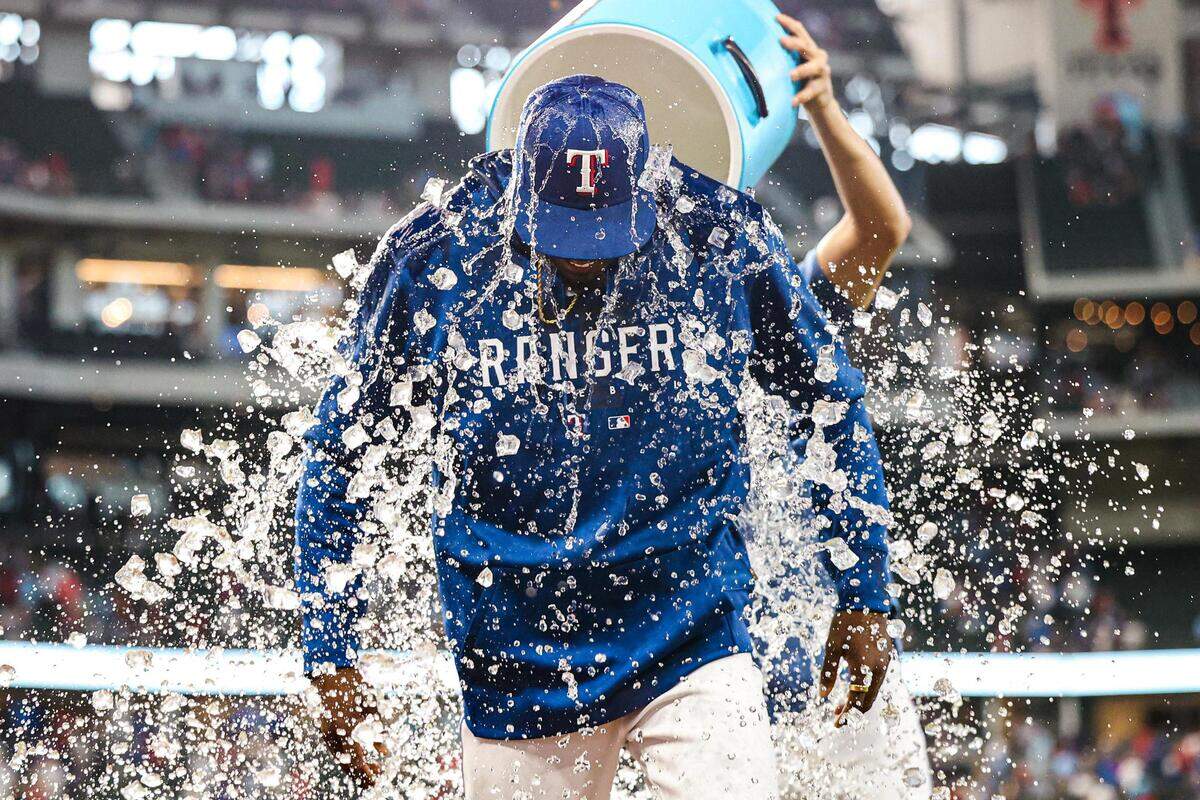 Texas Rangers pitcher Alex Speas (58) gets a ice water shower during his postgame interview after the Rangers defeated the Tampa Bay Rays 5-1 at Globe Life Field in Arlington, Texas on Wednesday, July 19, 2023. Speas, a second-round draft pick in 2016 who was coaching little league baseball last year, made his big league debut and struck out his first three batters in relief.