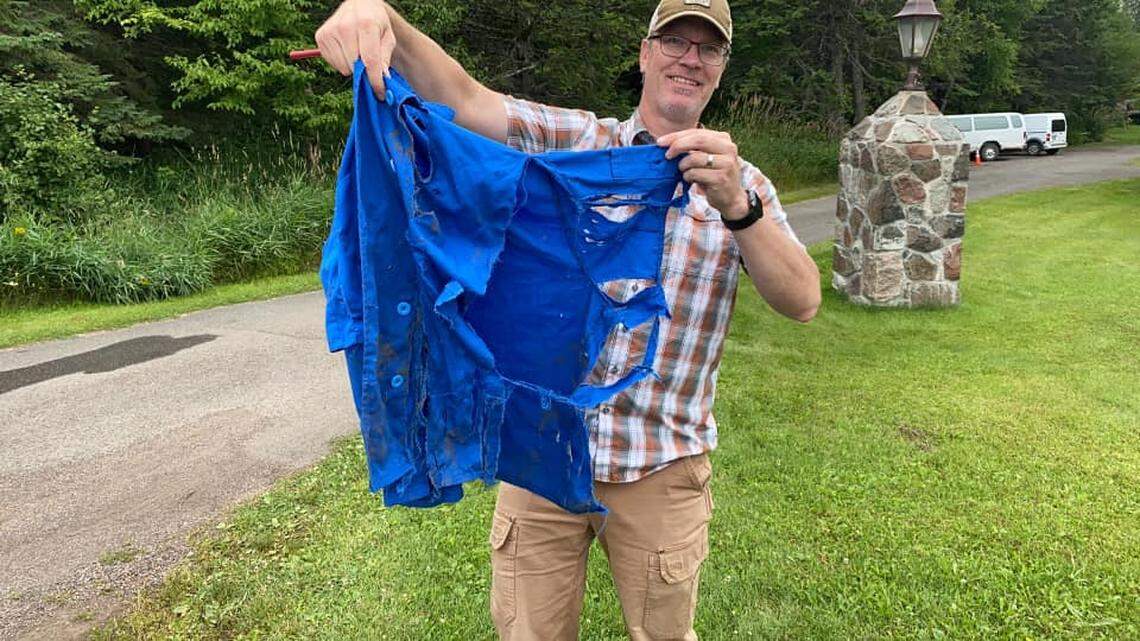 Man shows off the shirt that was thrown over the eagle to stop the attack.