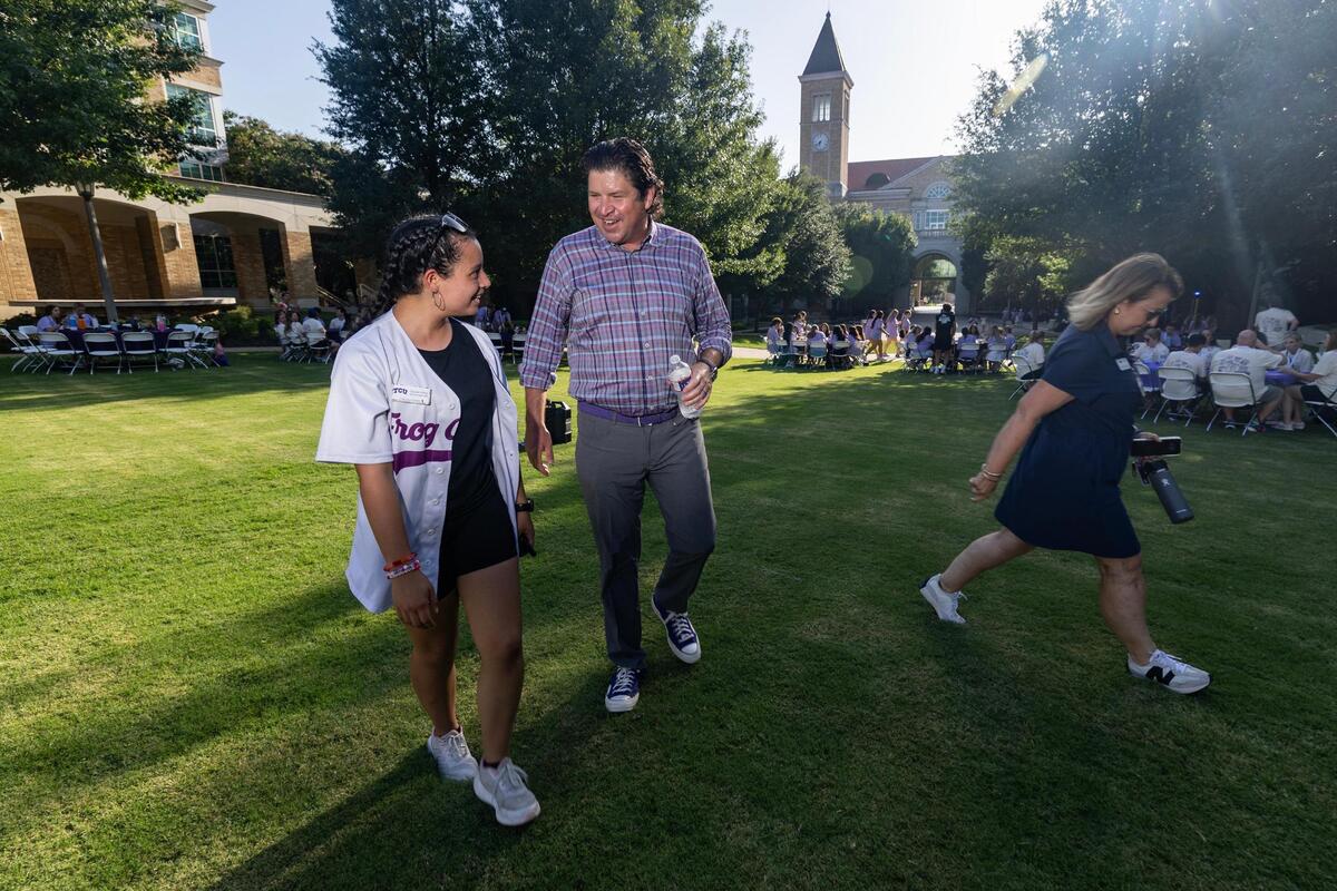 TCU Chancellor Daniel Pullin walks with Frog Camp director Claudia Urbina during a “Frog Camp” event on TCU’s campus on Friday, July 11, 2025.