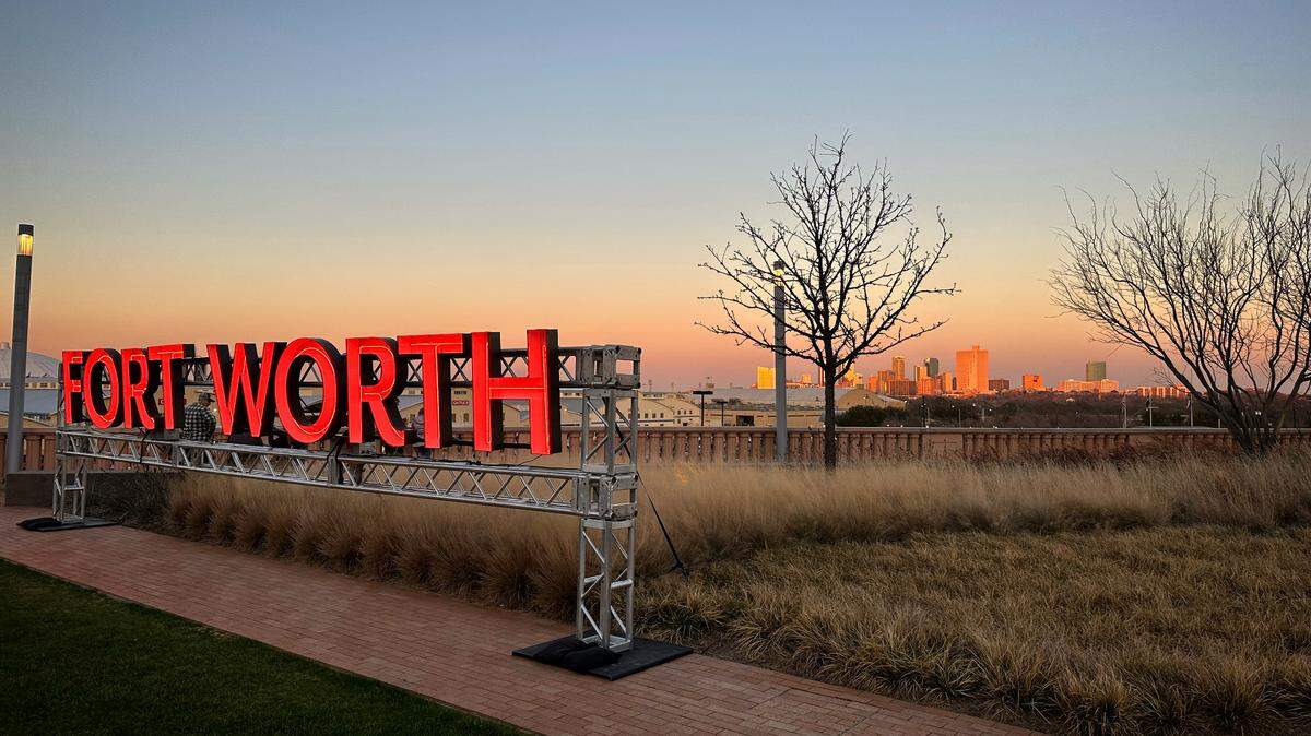 The illuminated Fort Worth sign near Dickies Arena, with the city’s skyline in the background