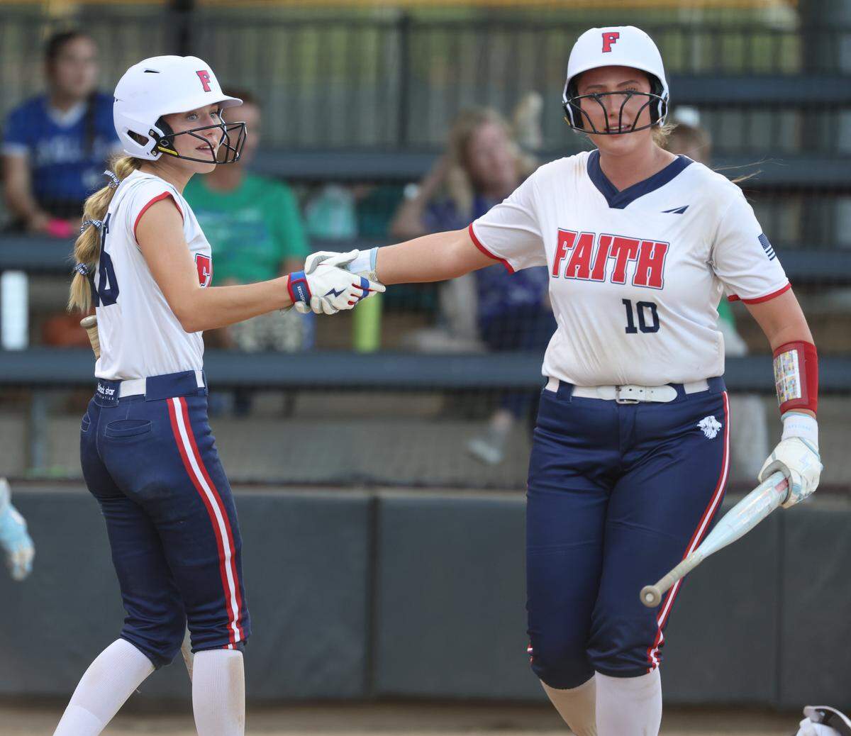 Grapevine Faith center fielder Michaela Hamilton (16) congratulates Elle Powers (10) after Powers scored a run during a softball game at Oak Grove Park in Grapevine, Tx. Tuesday, March 31, 2026