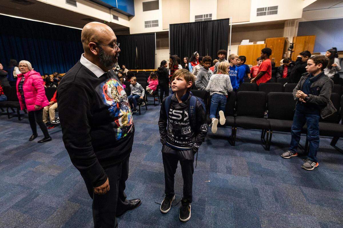 Orchestra director Julio Montañez speaks with student Nathaniel Friend, 11, during the Ridglea Elementary School visit at Applied Learning Academy in Fort Worth on Thursday.