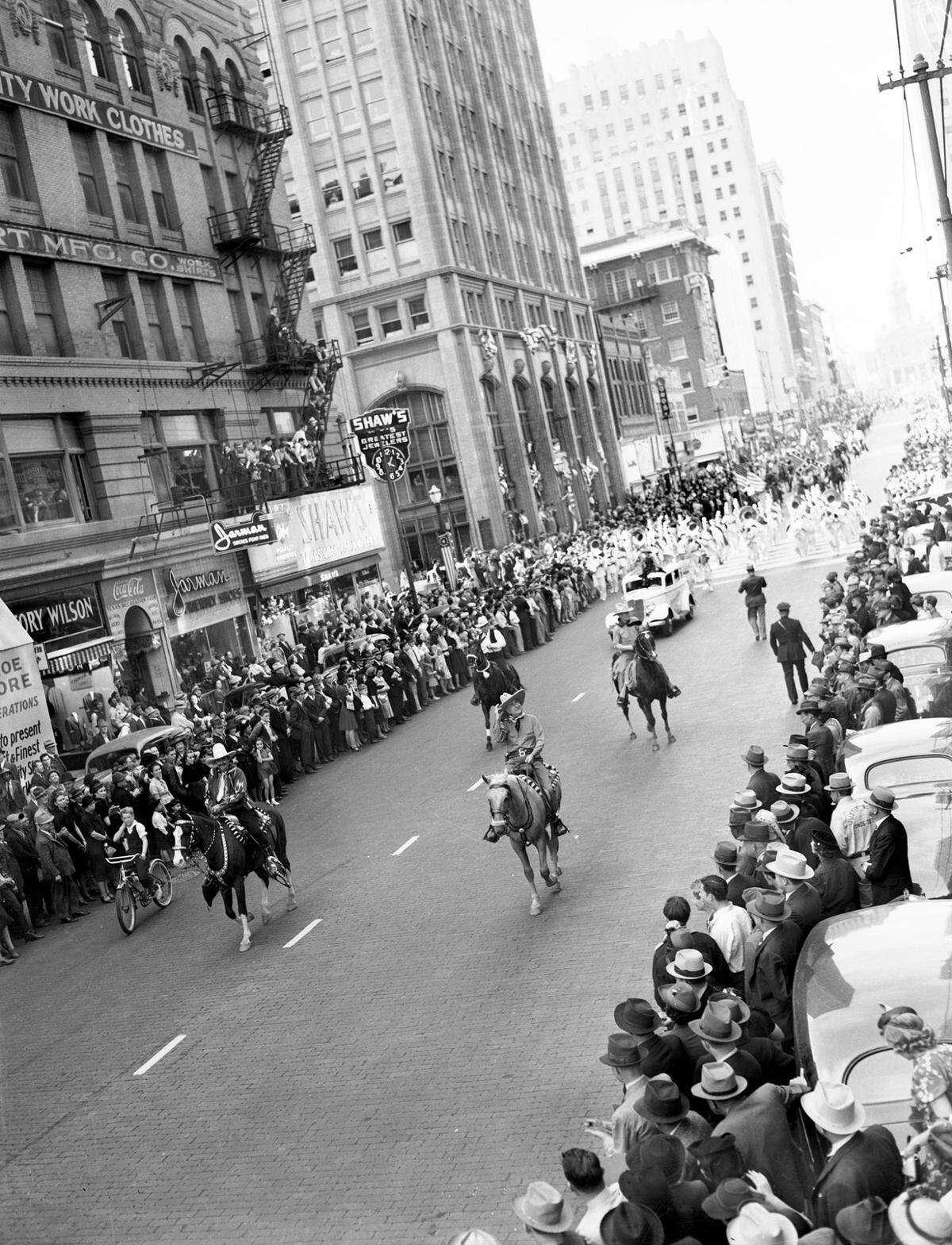 March 10, 1939: Amon Carter and others ride horses at the head of the parade to open the 43rd Southwestern Exposition and Fat Stock Show in Fort Worth. Behind the men on the horses is a marching band.