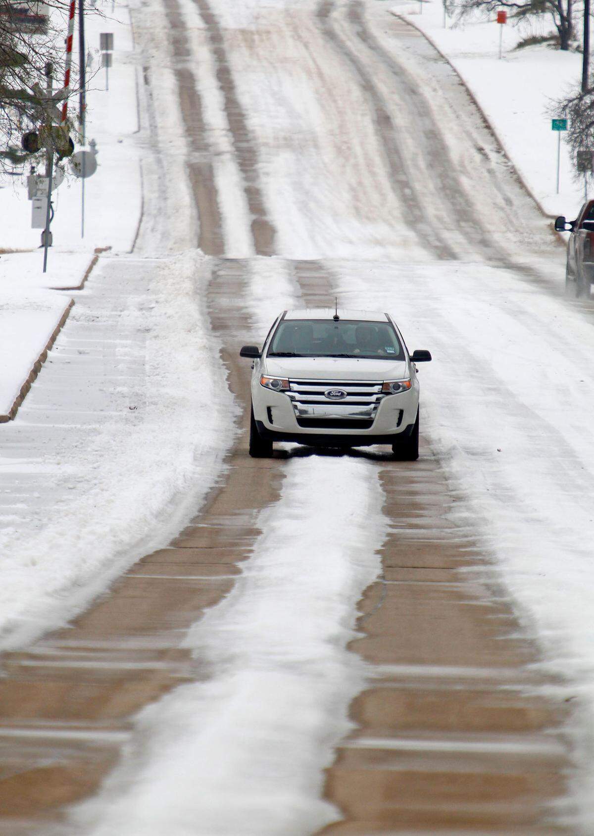 As temperatures rose, dry paths began to appear on the streets, Winscott Road near Z. Boaz Park here. Cold and ice remained in Fort Worth Sunday, with roads especially treacherous in the the morning hours before temperatures rose, Sunday, December 8, 2013. (Star-Telegram/Paul Moseley)