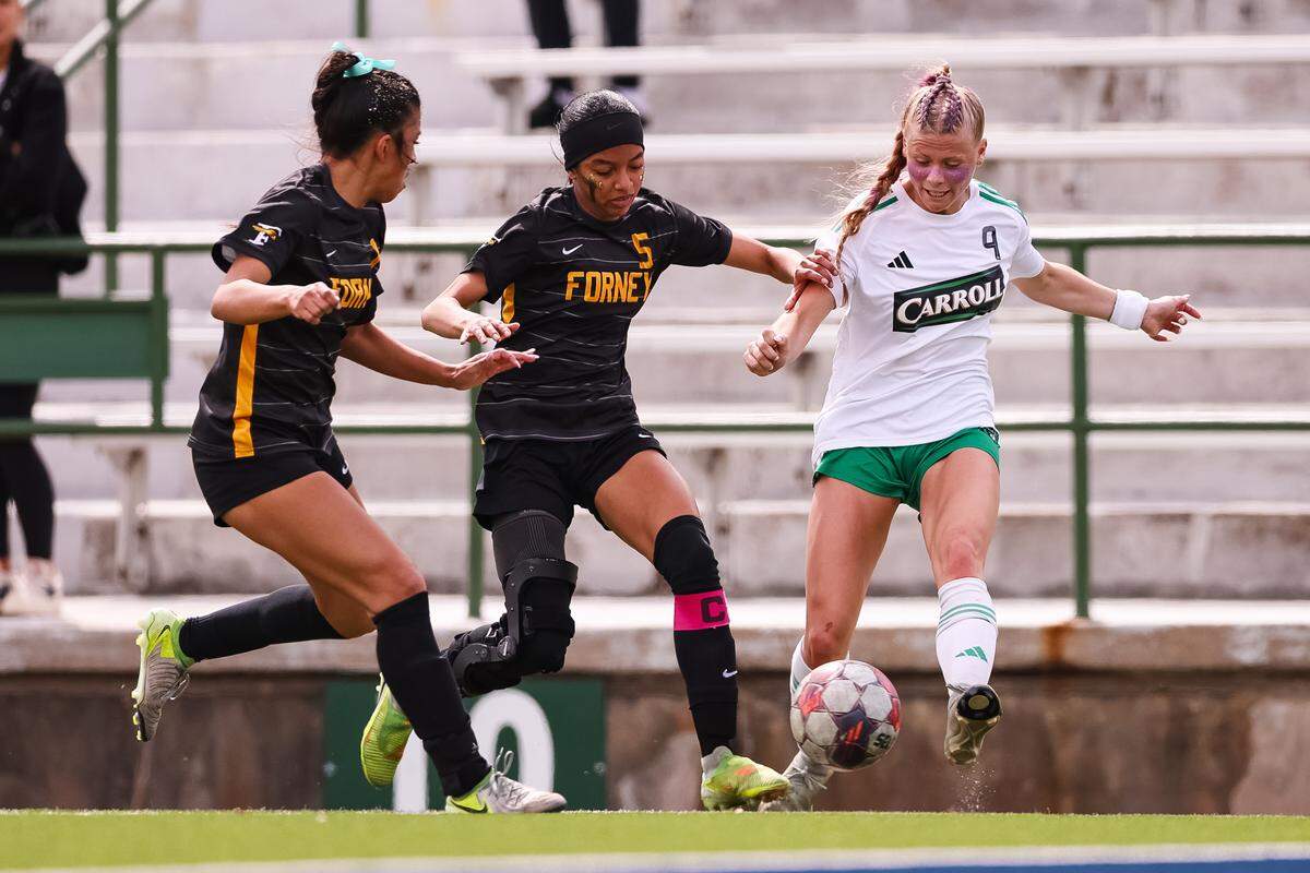 Southlake Carroll striker Caroline Holcombe (9) makes a pass from the corner surrounded by two Forney defenders in a UIL Class 6A Division 2 girls soccer state semifinal on Saturday, April 4, 2026, at Memorial Stadium in Mesquite, Texas.