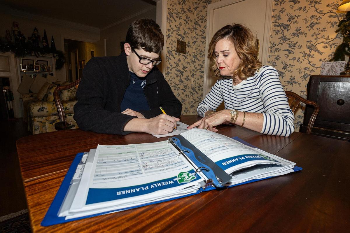High school sophomore Andrew James, 16, works with his mother, Caroline James, on English homework in the dining room at their family residence in Fort Worth on Dec. 12, 2024.