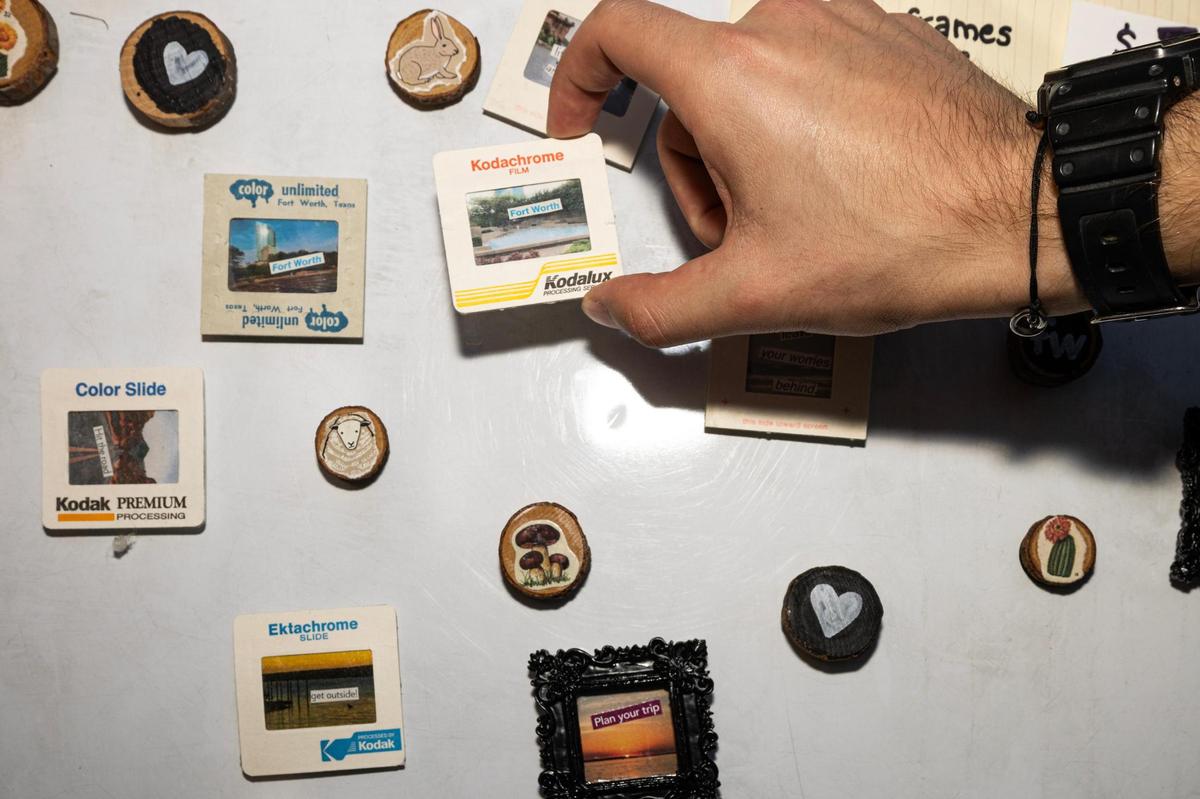 A customer takes one of the film photography themed magnets at an artist vendor during the Arts Goggle event on Magnolia Avenue in Fort Worth on Saturday, Oct. 19, 2024.