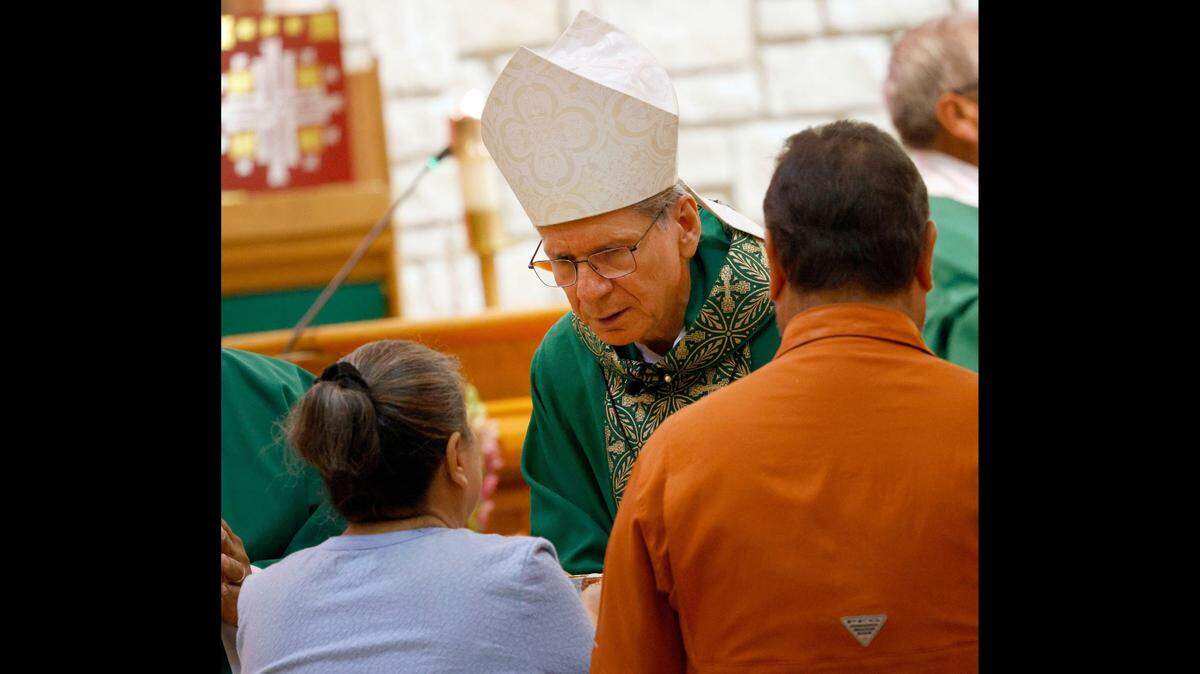 Archbishop Gustavo GarcÃŒa-Siller, center, speaks to Rosalie Castro of Kerrville and her husband Greg Castro during a mass at Notre Dame Church, Sunday, July 6, 2025, in Kerrville, Texas, to pray for those who have lost their lives and persons that are missing. (Chitose Suzuki/The Dallas Morning News/TNS)