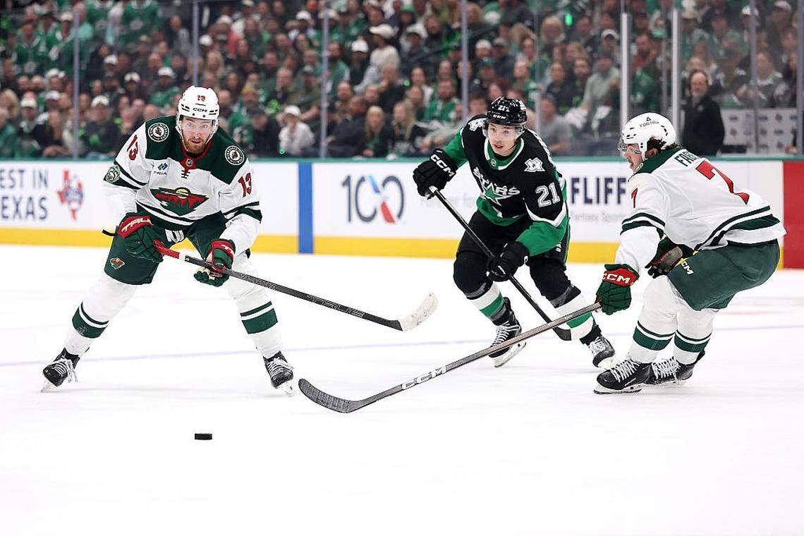 DALLAS, TEXAS - APRIL 20: Yakov Trenin #13 of the Minnesota Wild and Jason Robertson #21 of the Dallas Stars works for a loose puck during the first period of Game Two of the First Round of the 2026 Stanley Cup Playoffs at American Airlines Center on April 20, 2026 in Dallas, Texas. (Photo by Stacy Revere/Getty Images)