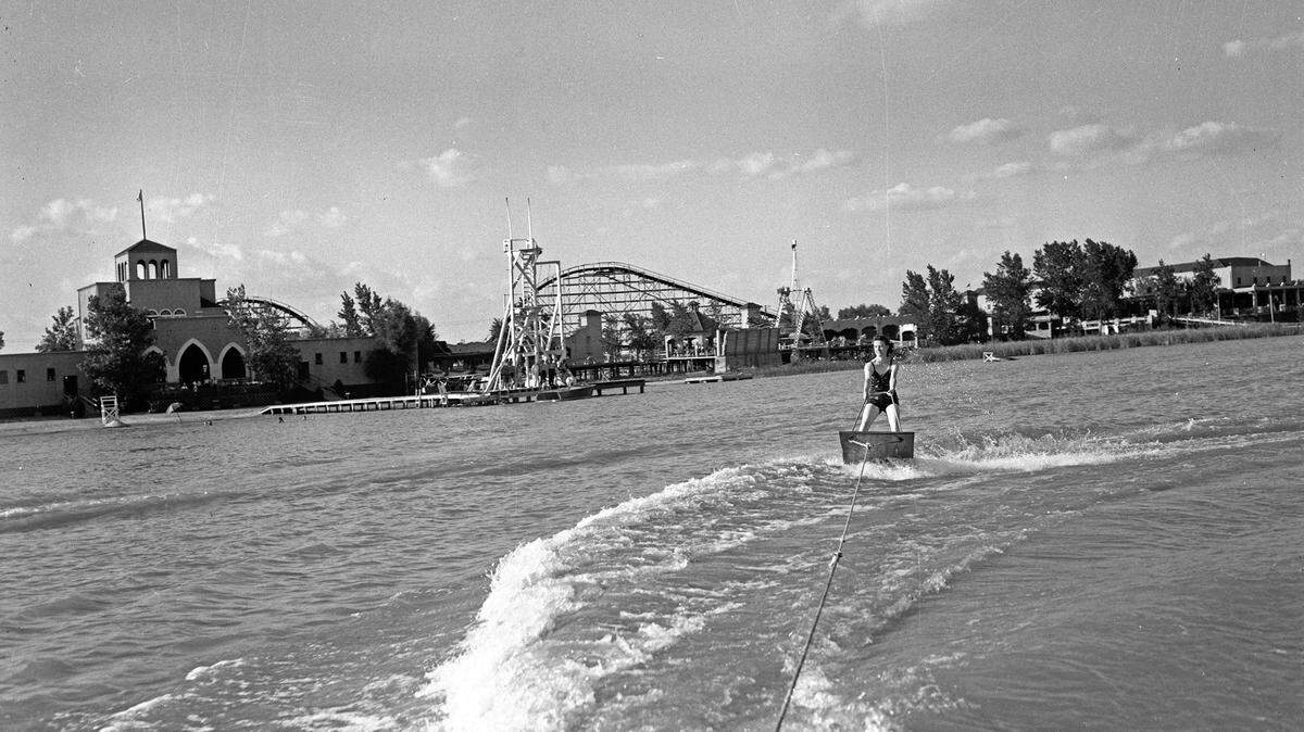 Sydnie Lunt rides an aquaplane behind a motor boat on Labor Day at Lake Worth with Casino Beach in the background in 1939.