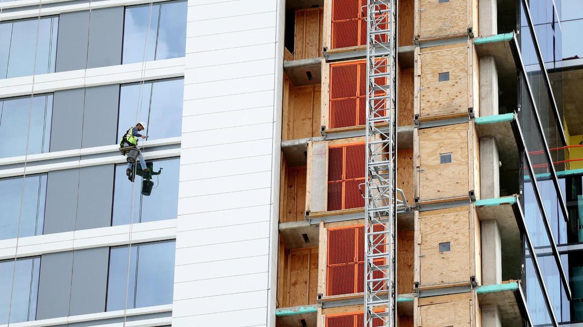 A worker cleans the windows on the partially constructed Loews Arlington Hotel and Convention Center in the city’s entertainment district on Feb. 13. Nearly $1 billion in construction projects are in the works, including a residential tower and a museum.