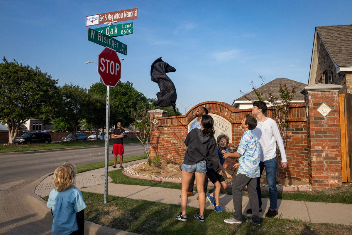 Councilman Jared Williams helps Abigail, 16, Chris, 12, Micah, 14, and Wesley Arbour, 18, unveil a street sign dedicated to their parents in the Summer Creek Ranch neighborhood of Fort Worth on Wednesday, May 3, 2023. Meg and Ben Arbour were killed in a car accident caused by two vehicles racing at night in November 2020.
