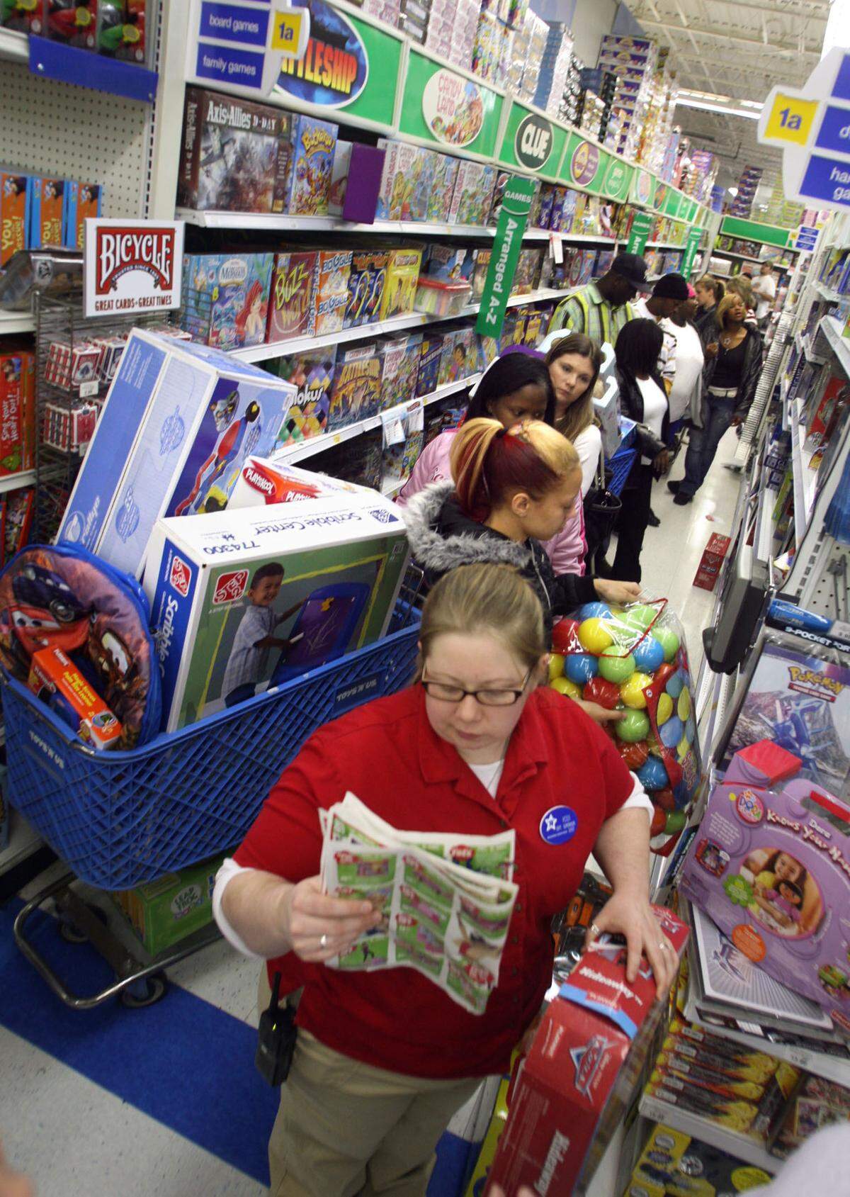 Nov. 23, 2007: Kodi Ervin, a department supervisor, helps shoppers at Toys R Us in Arlington who lined up before 5 a.m. looking for Christmas bargains.