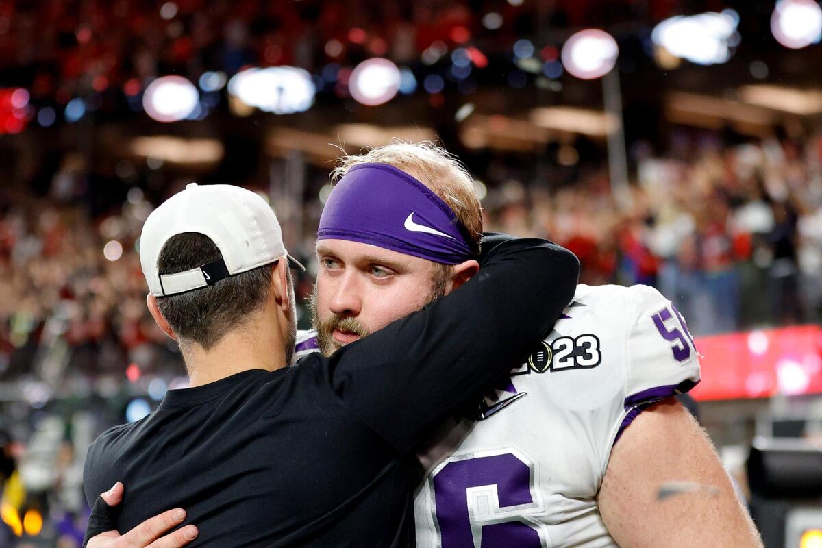TCU offensive lineman Alan Ali hugs a coach as he exits the field after Georgia beat the team during the College Football Playoff National Championship on Monday, Jan. 9, 2023, at SoFi Stadium in Inglewood, Calif. The Bulldogs defeated the Horned Frogs, 65-7.