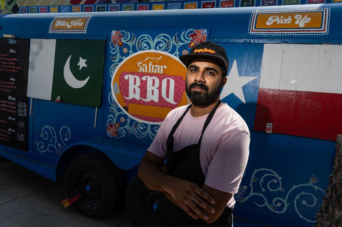 Zain Shafi, the owner of Sabar BBQ, is photographed at his barbecue trailer parked at the corner of East Vickery Boulevard and South Main Street near downtown Fort Worth. After learning the basics of barbecue while working at Goldee’s near Kennedale, Shafi opened Sabar in 2023. The menu blends Central Texas-style smoked meats with traditional dishes from Pakistan, where his family is from.