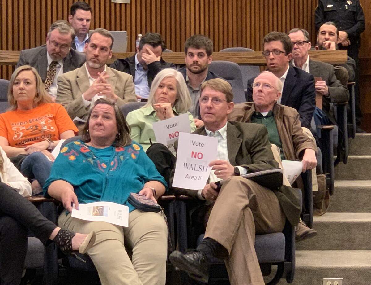 Several dozen residents protested plat revisions for the Walsh master-planned development at Fort Worth City Hall, including some who held paper signs. Despite the opposition, the City Plan Commission approved the revisions.