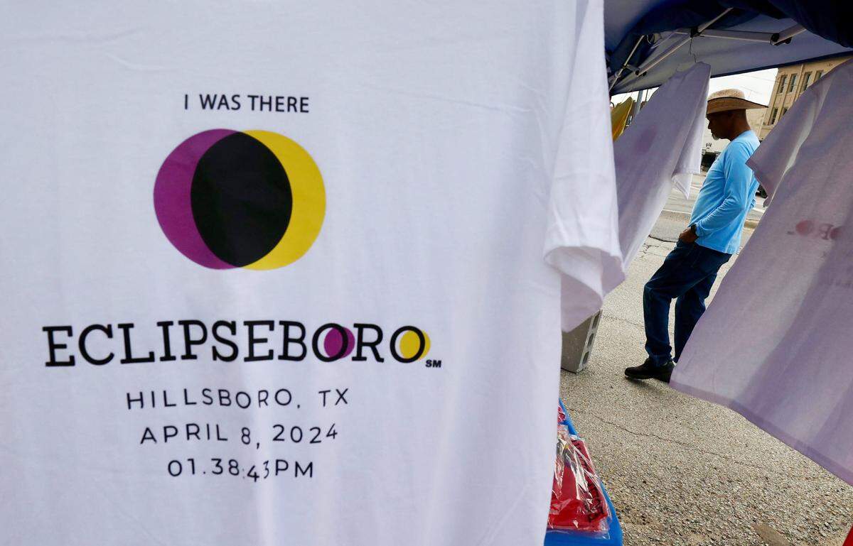 A man is framed by t-shirts saying "I was there, Eclipseboro." 