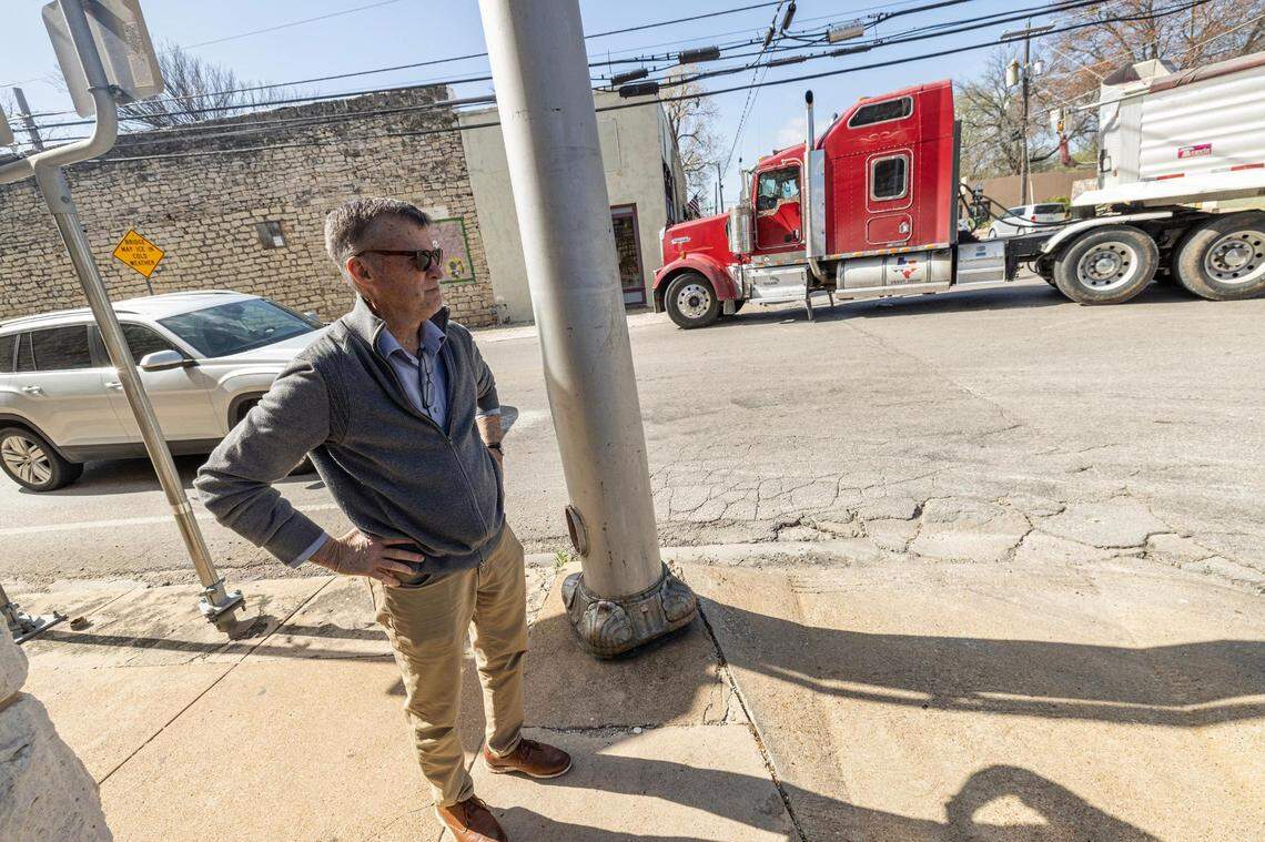 Glen Rose City Administrator Troy Hill looks on as a semi truck makes a wide left turn to avoid clipping the car waiting at a stop light at E Elm Street.