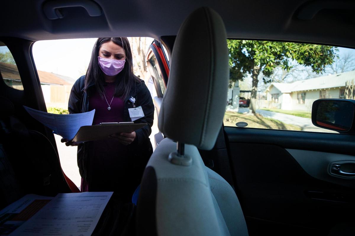 Anabel Montes, a service coordinator with MHMR Tarrant County, looks over paperwork before heading to visit a family Wednesday, March 24, 2021, in Fort Worth. MHMR and Fort Worth ISD teamed up to do visits in an effort to reach students who are disengaged from school during the pandemic.