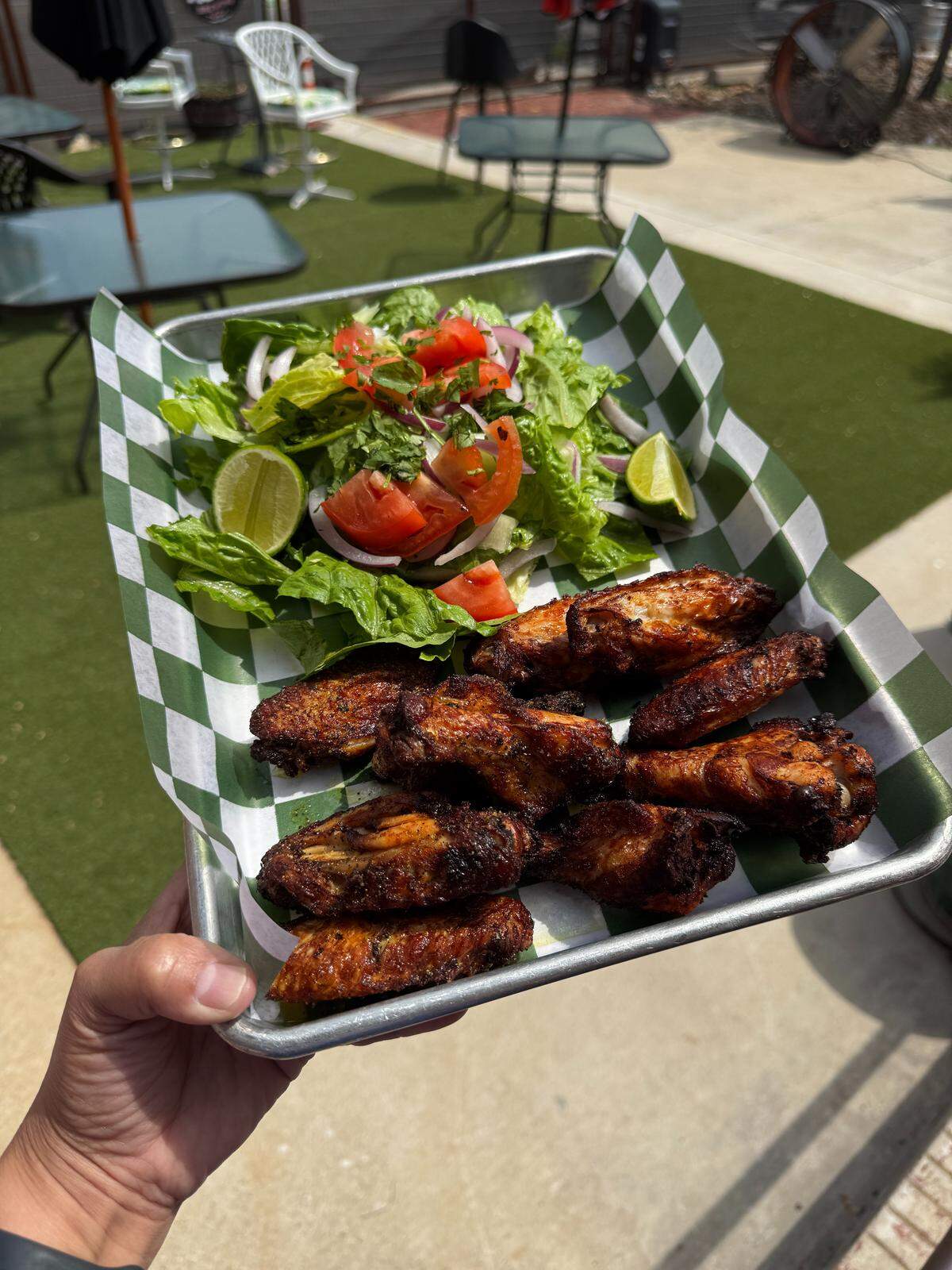 Lemon pepper wings seen along with a side salad Aug. 3, 2025 on the patio of Our Taphouse in Near Southside Fort Worth, Texas. They also offer flavors like house buffalo sauce, house buffalo/lemon pepper mix and sweet thai.