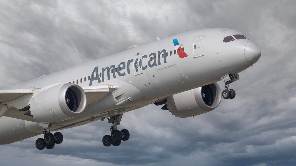 An American Airlines plane soars in the sky.