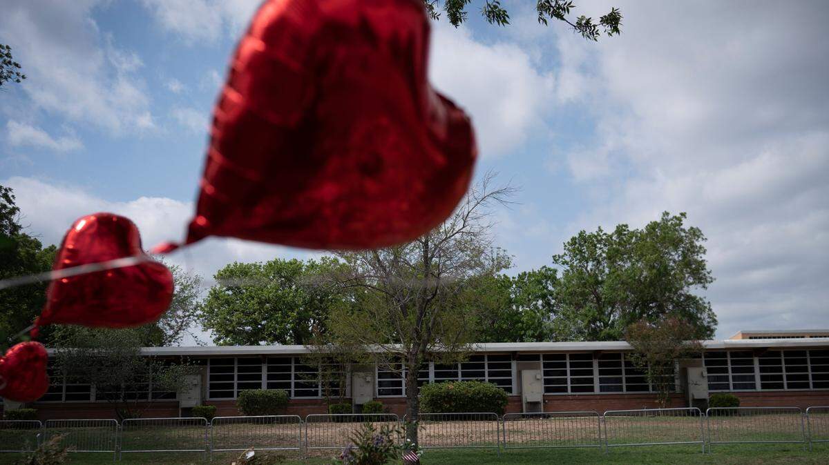 A heart-shaped balloon flies Monday, May 30, 2022, decorating a memorial site outside Robb Elementary School in Uvalde, Texas. Nineteen children and two teachers were killed by an 18-year-old gunman at the school.