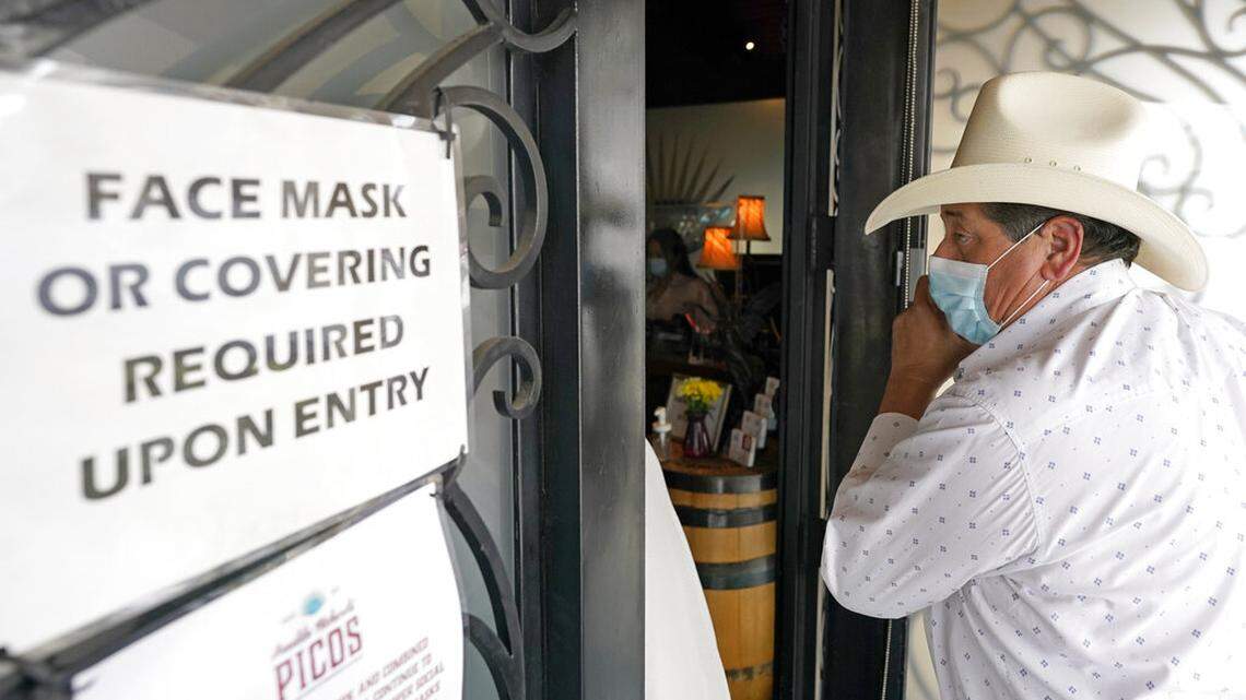 Sergio Almaguer wears a mask as he enters Picos Mexican restaurant Wednesday, March 10, 2021, in Houston. Picos, like many restaurants across the state, continue to operate at a reduced capacity and ask customers to wear masks despite Texas Gov. Greg Abbott ending state mandates for COVID-19 safety measures Wednesday. (AP Photo/David J. Phillip)
