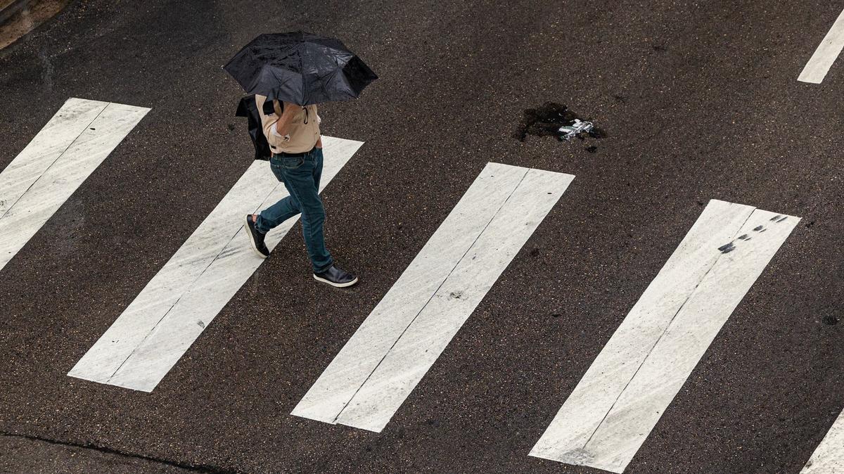 A pedestrian crosses the street in the rain at W 6th Street in downtown Fort Worth on Tuesday, Sept. 3, 2024.