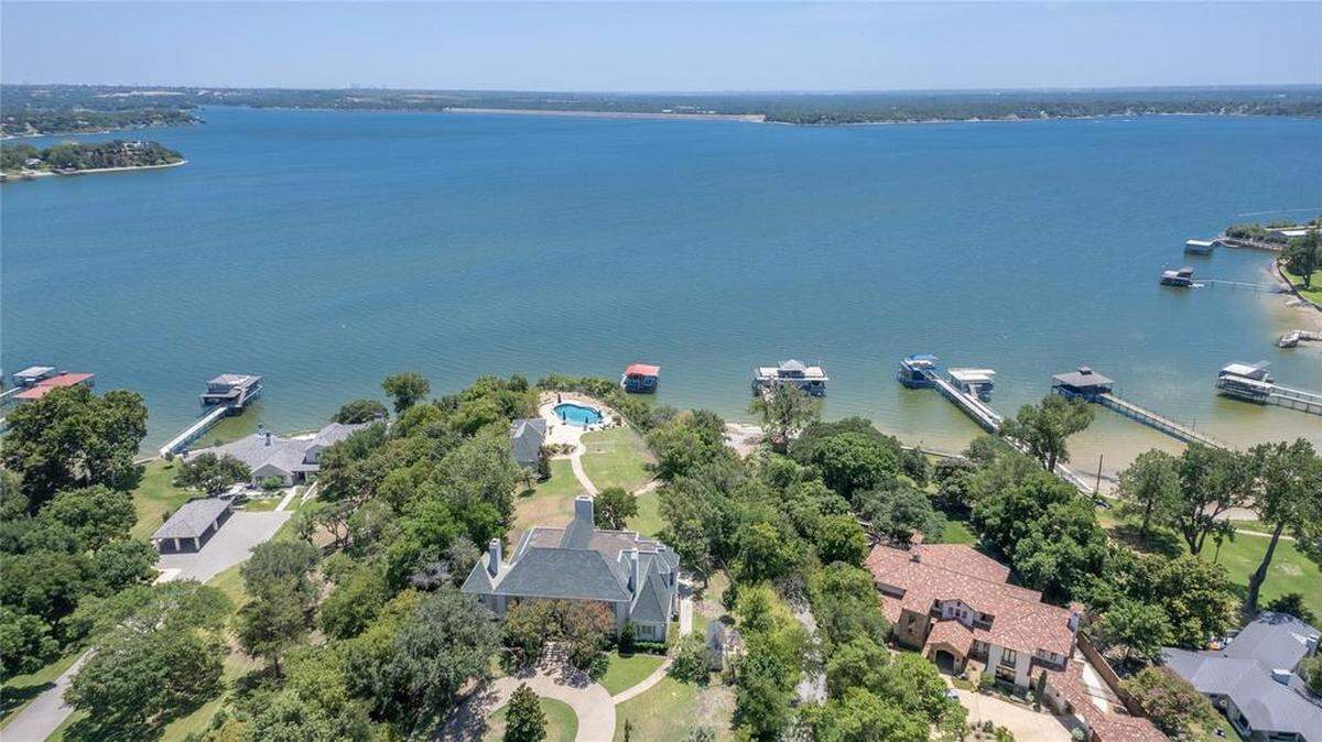 The French mansard mansion on Boat Club Road sits on the east side of Eagle Mountain lake with 180 degree lake views of the Fort Worth Boat Club and the city of Azle.