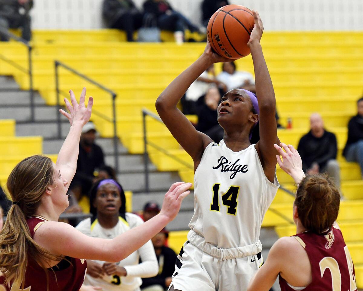 Fossil Ridge’s Jade Masogayo, left takes a jump shot against Central’s Caitlin Kobiske, left and Kate Layton during the third period of Tuesday’s January 28, 2020 basketball game at Fossil Ridge High School in Keller. Texas. The Fossil Ridge girls wore purple head bands as a tribute to Kobe Bryant in their 53-42 loss to Central. Special/Bob Haynes