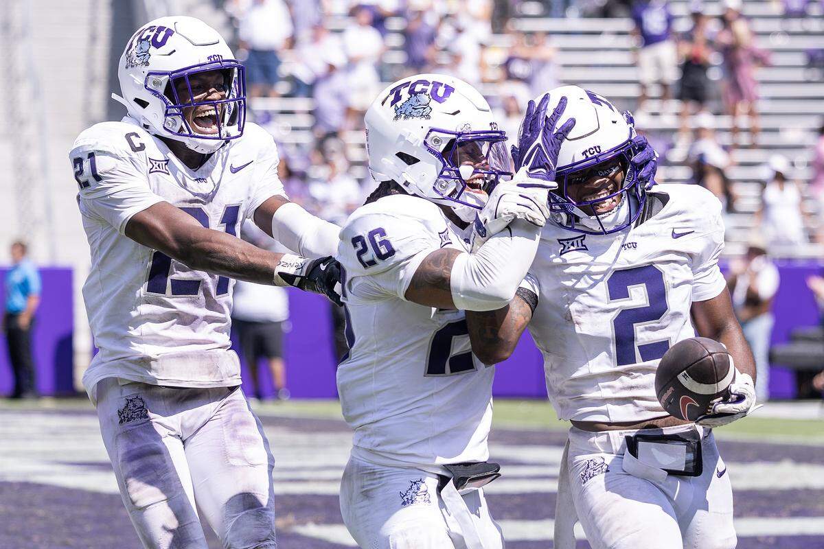 TCU safety Bud Clark (21) and cornerback Vernon Glover (26) celebrate with safety Jamel Johnson (2) after Johnson got the game sealing interception in the second half of an NCAA football game between TCU and SMU at Amon G. Carter Stadium in Fort Worth on Saturday, Sept. 20, 2025. TCU won 35-24 in the final Iron Skillet Rivalry game.