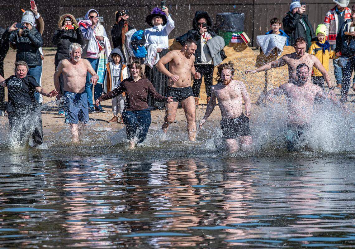 Dozens of hearty souls including Dallas residents Madison Talmage, third from left, and Jake Davis, second from right, ran into cold Lake Granbury for the fourth edition of the Goosebump Jump in Granbury, Texas, Saturday, Jan. 20, 2024.